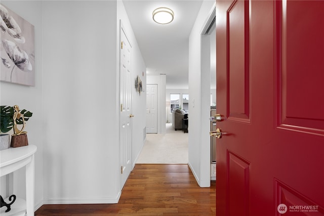 hallway featuring baseboards and wood finished floors