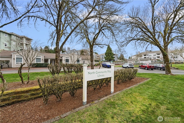 community sign with a lawn and a residential view