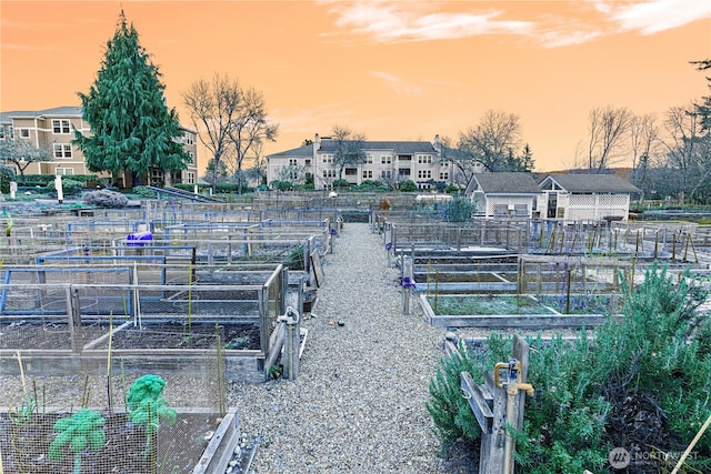 yard at dusk featuring a garden