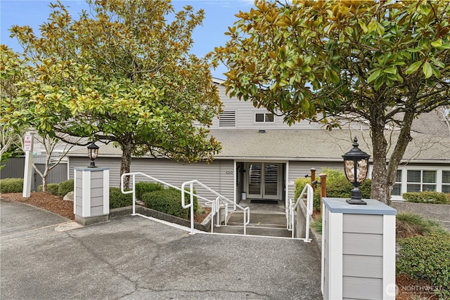 view of front of house with french doors, a patio, fence, and a shingled roof