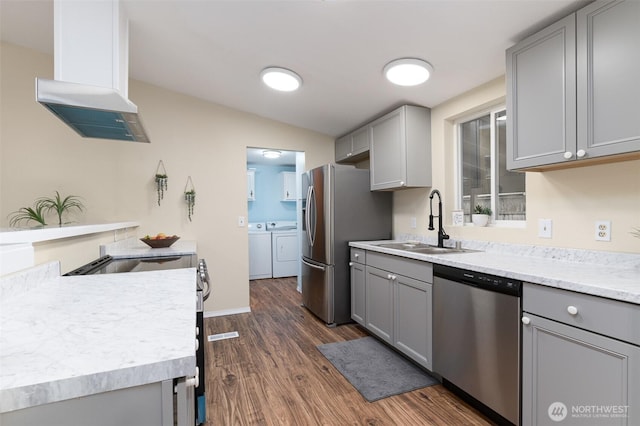 kitchen with washer and dryer, stainless steel appliances, extractor fan, and gray cabinets