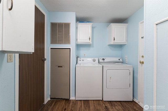 clothes washing area with visible vents, dark wood-style floors, cabinet space, baseboards, and washing machine and clothes dryer