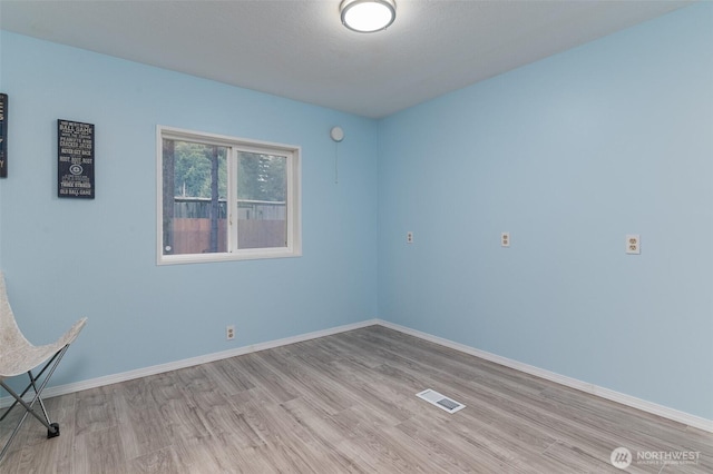 unfurnished room with visible vents, baseboards, and light wood-style floors