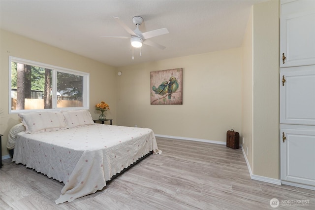 bedroom featuring light wood-style flooring, baseboards, and ceiling fan