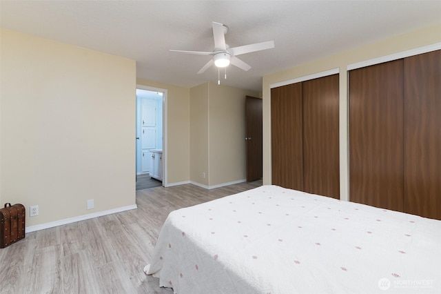 unfurnished bedroom with light wood finished floors, two closets, ceiling fan, baseboards, and ensuite bath