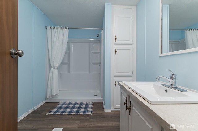 full bath featuring a shower with curtain, wood finished floors, and vanity