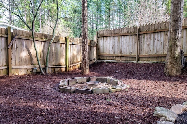 view of yard with a fenced backyard and an outdoor fire pit