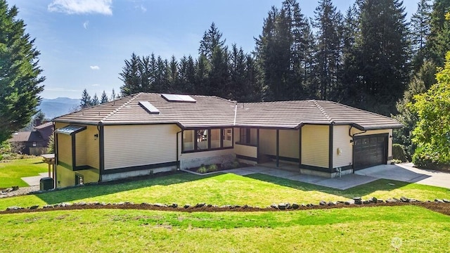 view of front of property with driveway, a front lawn, an attached garage, and a tile roof