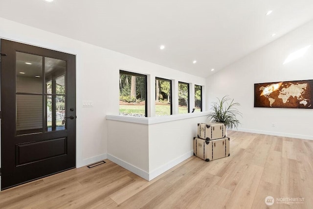 entrance foyer with vaulted ceiling, baseboards, visible vents, and light wood finished floors