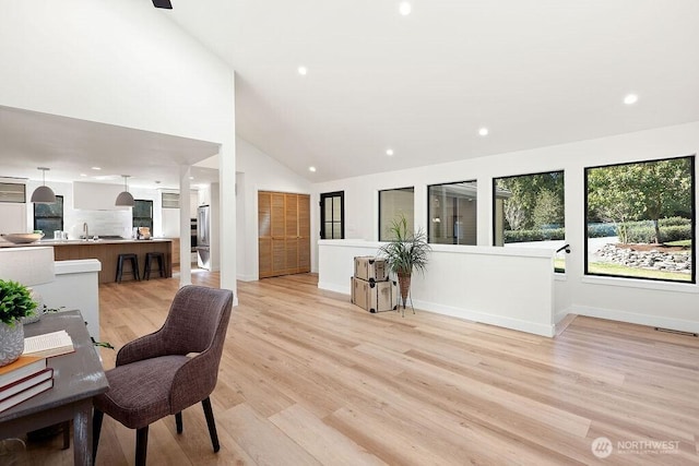 home office featuring light wood finished floors, recessed lighting, high vaulted ceiling, and baseboards