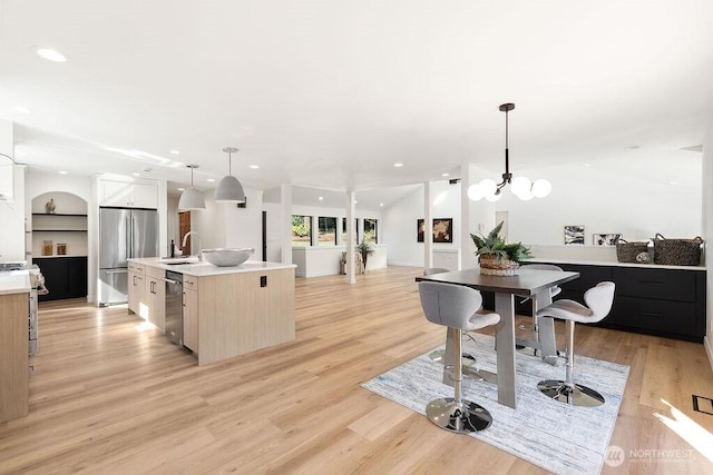 kitchen featuring light wood-style flooring, recessed lighting, a sink, light countertops, and appliances with stainless steel finishes