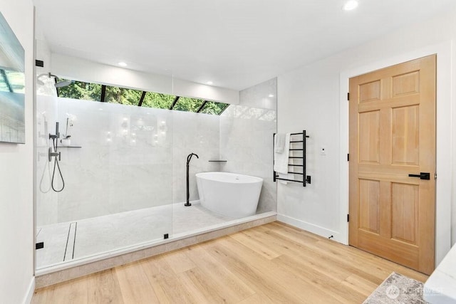 full bath featuring a walk in shower, wood finished floors, recessed lighting, baseboards, and a freestanding bath