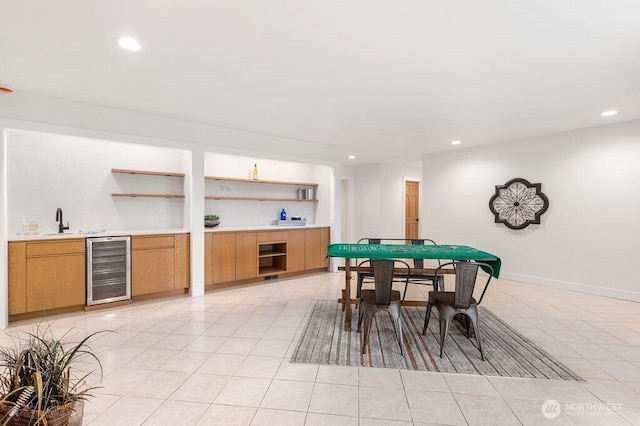 rec room featuring wine cooler, light tile patterned flooring, wet bar, and a sink