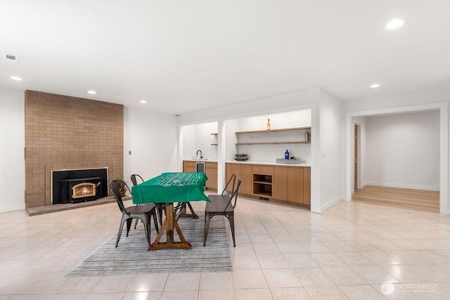 dining space featuring a fireplace, recessed lighting, and baseboards