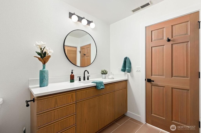 bathroom with tile patterned floors, visible vents, baseboards, and vanity