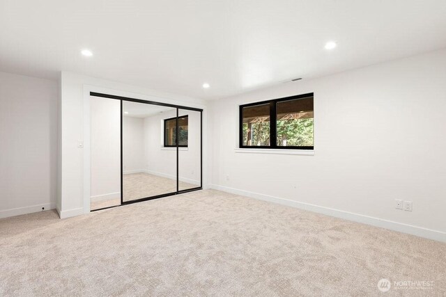 unfurnished bedroom with recessed lighting, light colored carpet, and baseboards