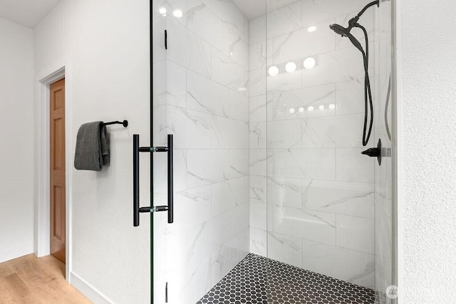 bathroom featuring wood finished floors and a stall shower