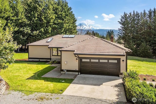 view of front of home featuring driveway, a front lawn, a tiled roof, a mountain view, and roof mounted solar panels