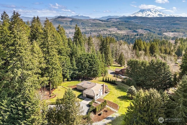 birds eye view of property with a mountain view and a wooded view