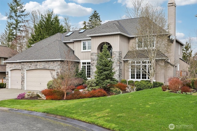 view of front facade featuring a front lawn, concrete driveway, a chimney, a garage, and stone siding