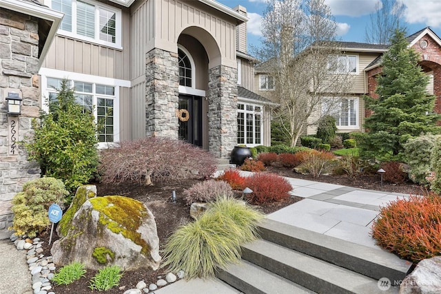 doorway to property with stone siding and board and batten siding