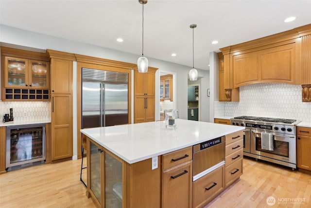 kitchen with a warming drawer, light wood-style floors, high end appliances, and beverage cooler