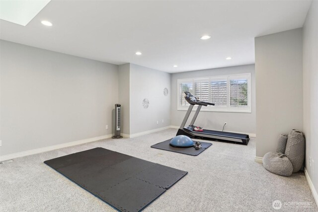 exercise area with recessed lighting, baseboards, a skylight, and carpet flooring