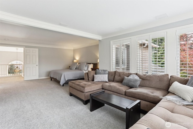 carpeted living room with baseboards, a healthy amount of sunlight, and crown molding