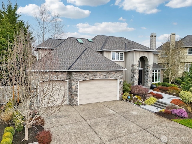 french country style house featuring stone siding, roof with shingles, concrete driveway, and an attached garage