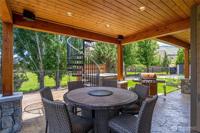 view of patio with a fenced backyard, outdoor dining space, stairway, and area for grilling