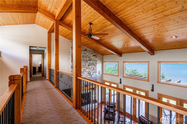 hallway with a healthy amount of sunlight, high vaulted ceiling, and an upstairs landing
