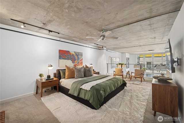 bedroom with baseboards, track lighting, and carpet flooring