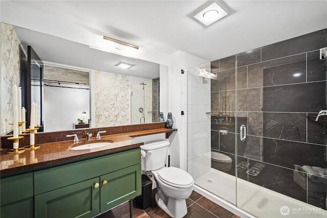 bathroom with vanity, a shower stall, and toilet