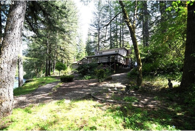 view of yard with a view of trees and a wooden deck