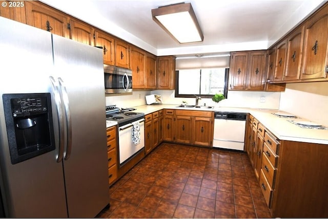 kitchen featuring a sink, light countertops, brown cabinets, and stainless steel appliances