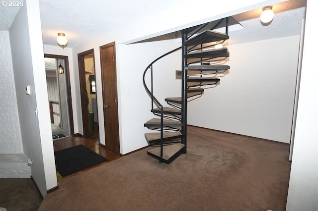 stairs with baseboards, a textured ceiling, and carpet