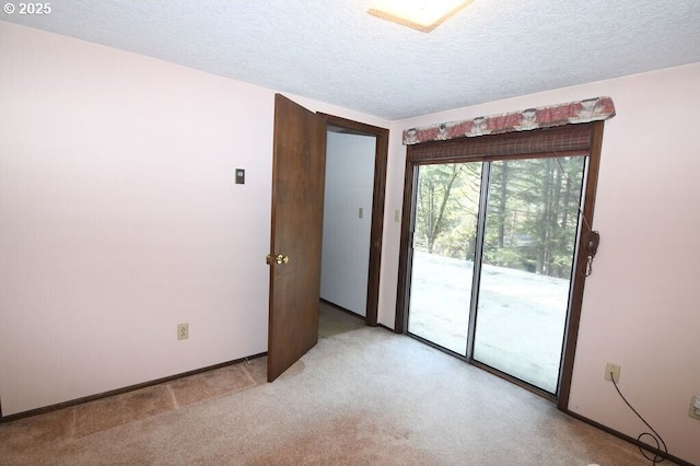 unfurnished room with baseboards, light carpet, and a textured ceiling