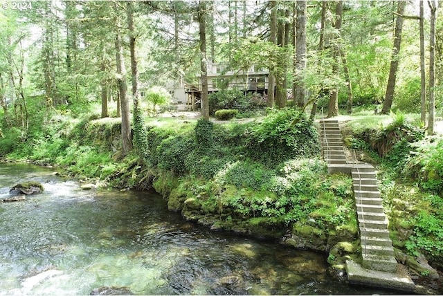 view of yard with a view of trees and stairs