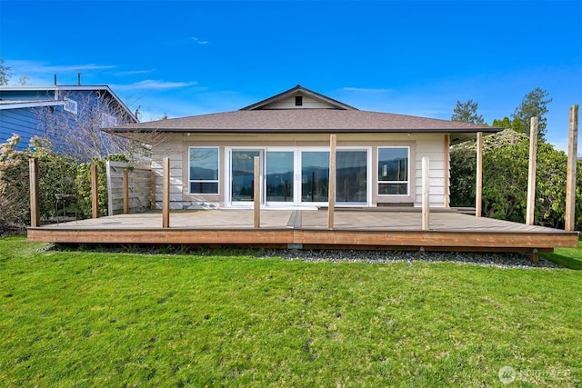 back of property with a yard and a wooden deck