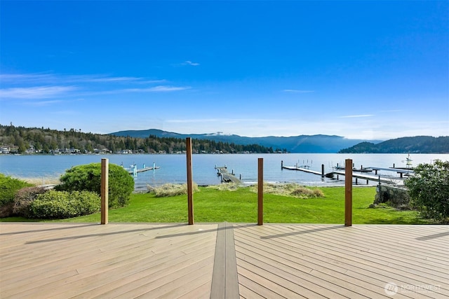 wooden terrace with a yard, a water and mountain view, and a boat dock