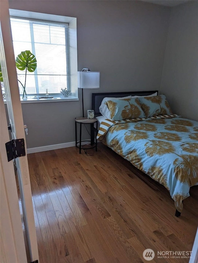 bedroom featuring wood finished floors and baseboards