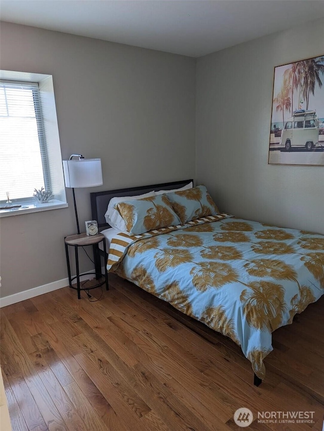 bedroom with wood finished floors and baseboards