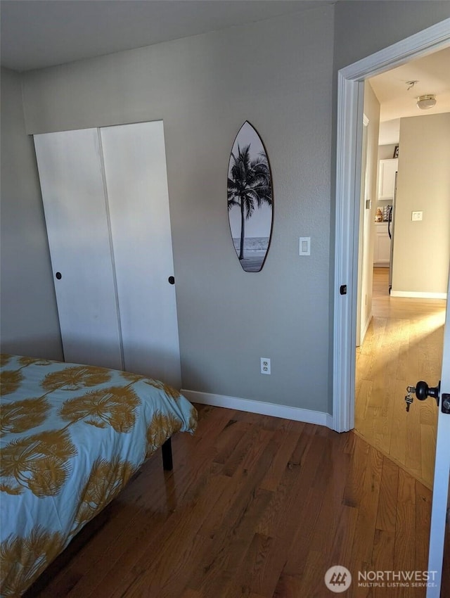 bedroom featuring a closet, baseboards, and wood finished floors