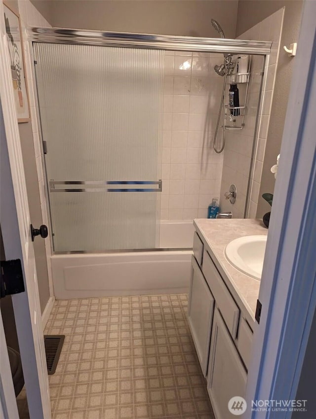 full bath with tile patterned floors, vanity, and bath / shower combo with glass door