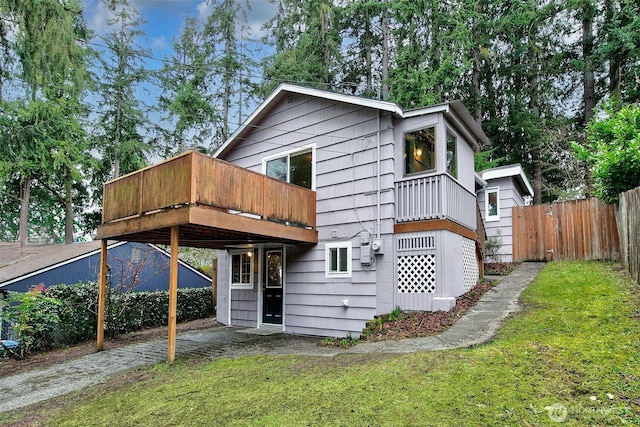 rear view of property with a yard and fence