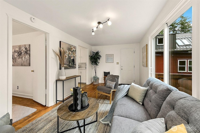 living area with baseboards and wood finished floors