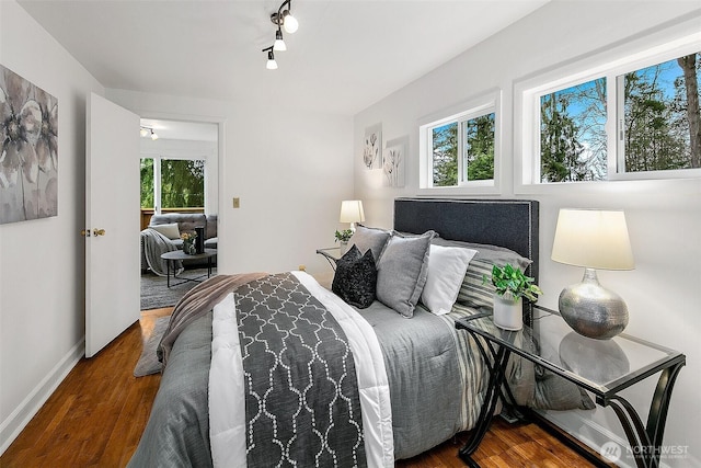 bedroom with baseboards and wood finished floors