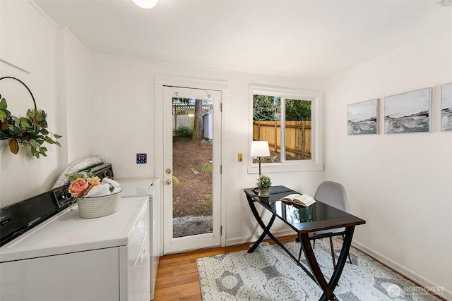 office featuring baseboards, independent washer and dryer, and light wood-type flooring