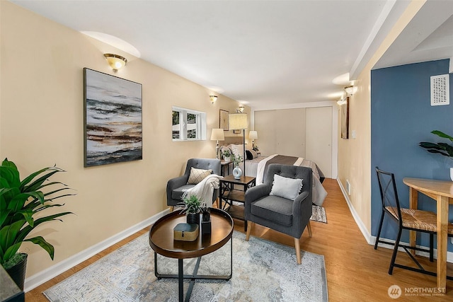 living area featuring visible vents, wood finished floors, and baseboards