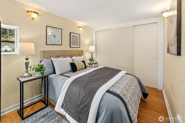 bedroom with a closet, baseboards, and wood finished floors